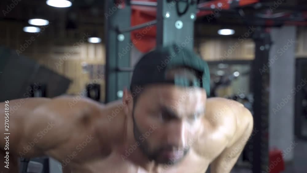 Athletic young man doing pulling up on horizontal bar at gym Athletic young man doing pulling up on horizontal bar at gym