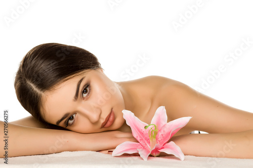 Young woman with makeup posing with flower on white background