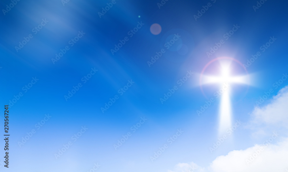 Holy light of crucifix cross on blue sky background. Hope and freedom concept.