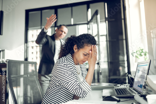 Employee having headache listening to angry boss