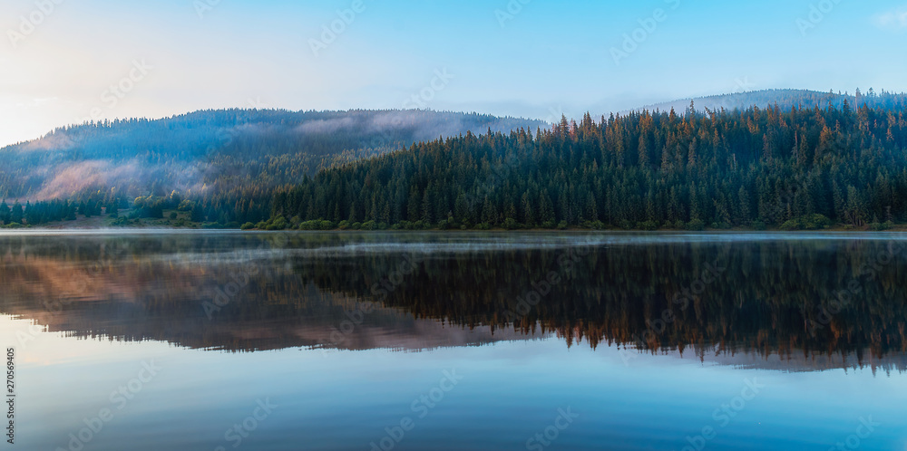 Mountain lake with fog and colorful sky, springtime 