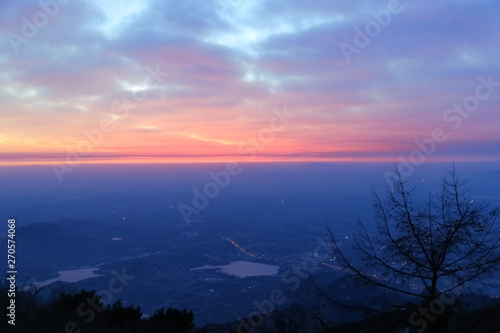 Sunrise view of mount tai. The direction of the mountains.The morning glow of sunrise.Clouds surge  colorful clouds at sunrise.The sunrise on the horizon.Overlooking the city and the lake