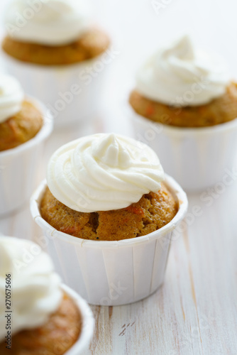 Carrot cupcakes with vanilla frosting. White wooden table, high resolution