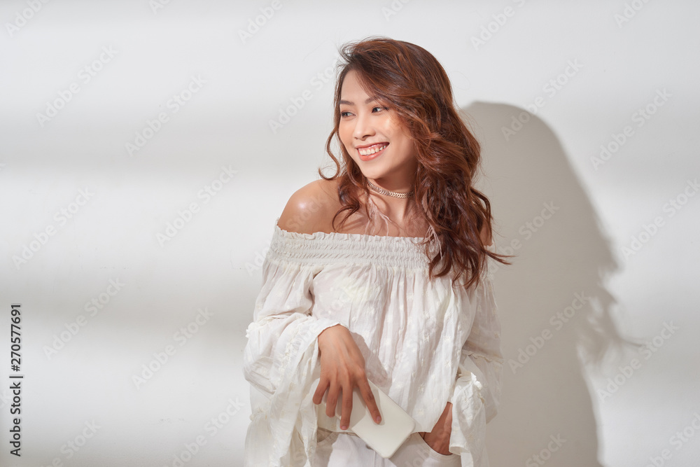 Smiling, positive asian woman with beautiful emotional face listening to music over white Smiling, positive asian woman with beautiful emotional face listening to music over white