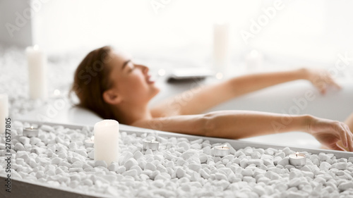 Woman Lying In Bath With Foam And Candles