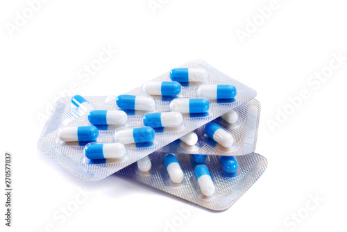 Tablou canvas pile of blister packs with blue and white capsules isolated on white background