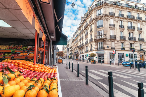 Fototapeta Naklejka Na Ścianę i Meble -  Streets of Paris, France. Blue sky, buildings, traffic and street fruit market.