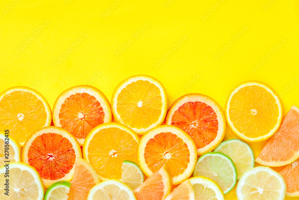 Citrus slices pattern on yellow background from above. Top view of orange, grapefruit, lime and lemon fruit slices on yellow background. Fruit summer cocktail pattern design Citrus slices pattern on yellow background from above. Top view of orange, grapefruit, lime and lemon fruit slices on yellow background. Fruit summer cocktail pattern design