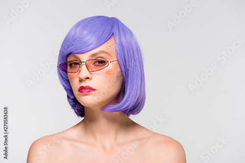 attractive girl in purple wig and sunglasses isolated on grey