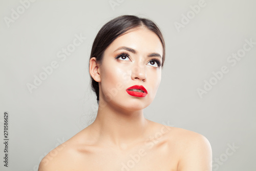 Beautiful healthy woman looking up on white background. Facial treatment and skincare concept