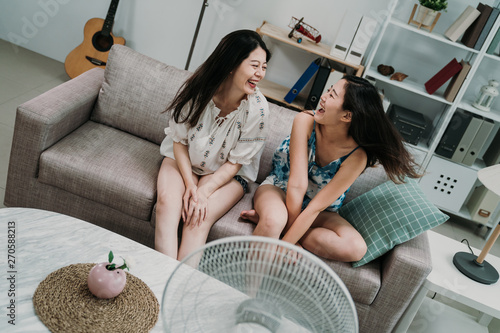 friends sitting on couch cooling off with fan photo