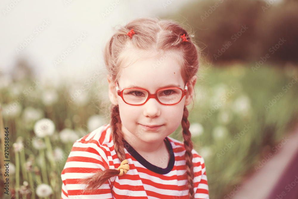 beautiful emotional girl with glasses playing with dandelions. childhood concept beautiful emotional girl with glasses playing with dandelions. childhood concept