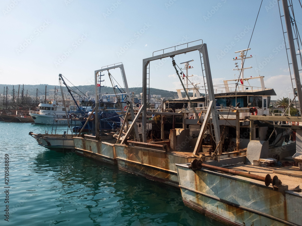 Old rusty fishermen boats with winch hoisting mechanisms in the harbor