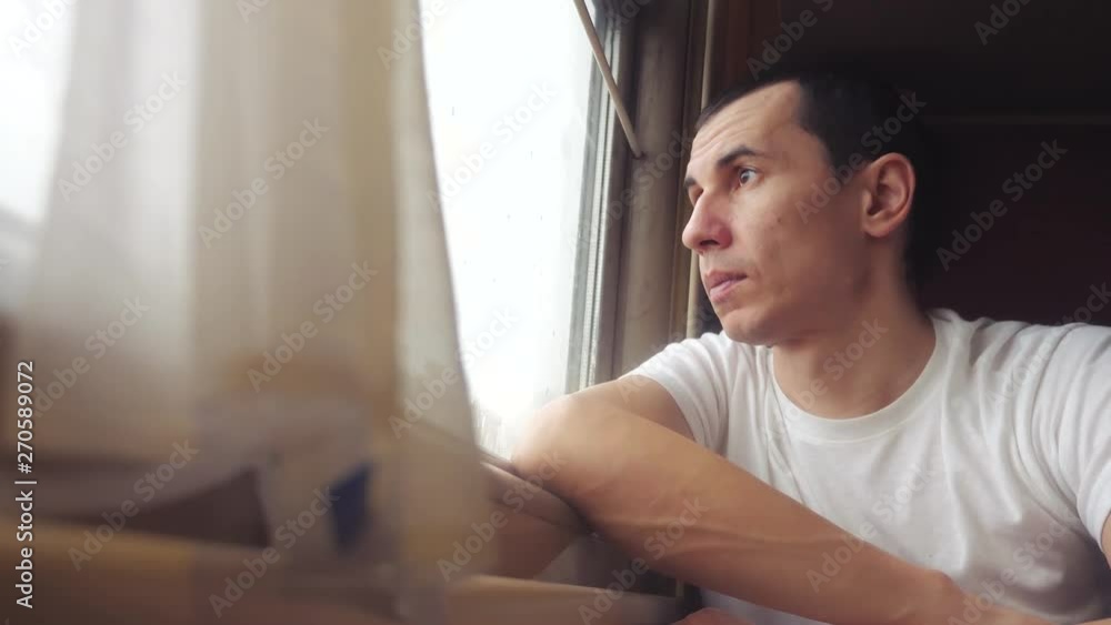 man rides train railway looks out the window. traveler concept train railroad journey lifestyle travel. slow motion video. beautiful from window of a moving train railway trip Russia winter man rides train railway looks out the window. traveler concept train railroad journey lifestyle travel. slow motion video. beautiful from window of a moving train railway trip Russia winter