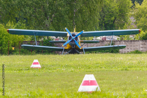 Soviet aircraft biplane Antonov AN-2 parked on a green grass of airfield photo