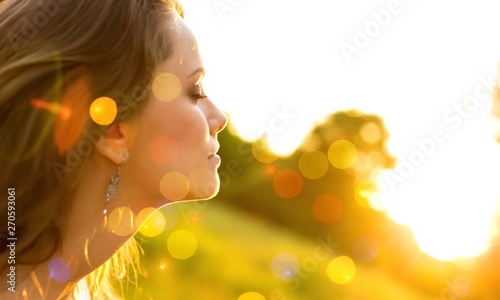 Young woman on field under sunset light