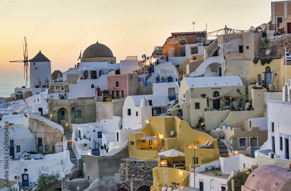 SANTORINI, GREECE - JUNE 2014: Sunset view of Oia buildings and streets. Oia is the major tourist attraction on the island