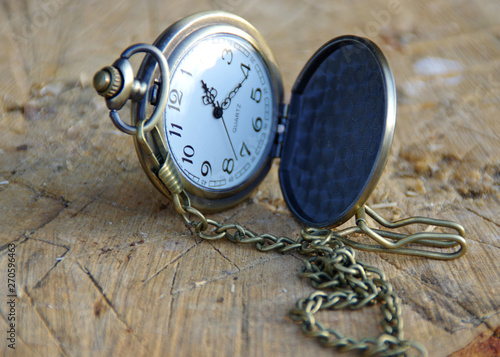Retro pocket watch on a wooden trunk