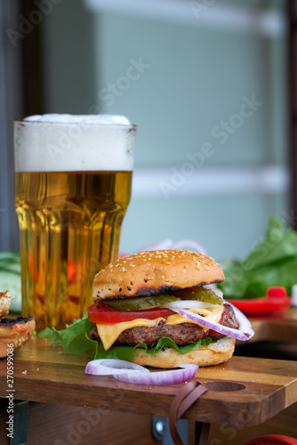 Tasty big burger and beer glass on wood table