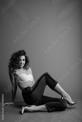 Young beautiful woman with curly hair posing in black and white
