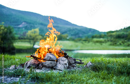 Burning fire in nature on the background of the lake The embers in the fire. Burning coal in the bonfire. 