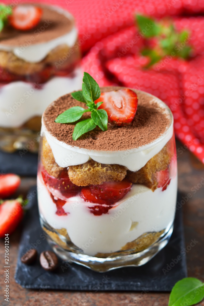 Italian dessert tiramisu with strawberries on an old grunge background Italian dessert tiramisu with strawberries on an old grunge background