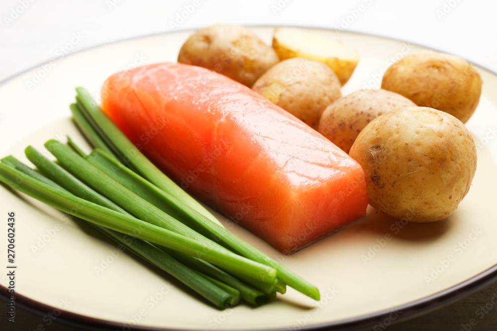 Boiled young potatoes with red fish and green onions