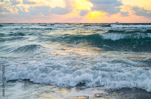 Sea coast with waves at sunset