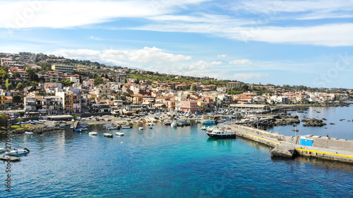 Fototapeta Naklejka Na Ścianę i Meble -  Acitrezza Sicily aerial scenic panorama of the town, the port, blue sea and beautiful sky