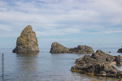 Acitrezza Sicily cyclopean islands near the rocky coastline, beautiful seascape and blue sky
