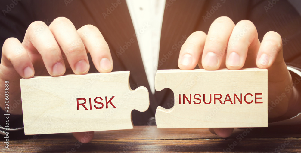 Businessman collects wooden puzzles with the word Risk insurance. The transfer of certain risks