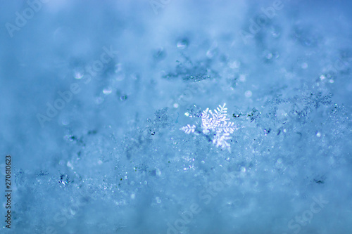 brilliant snowflake on the background of blue snow.