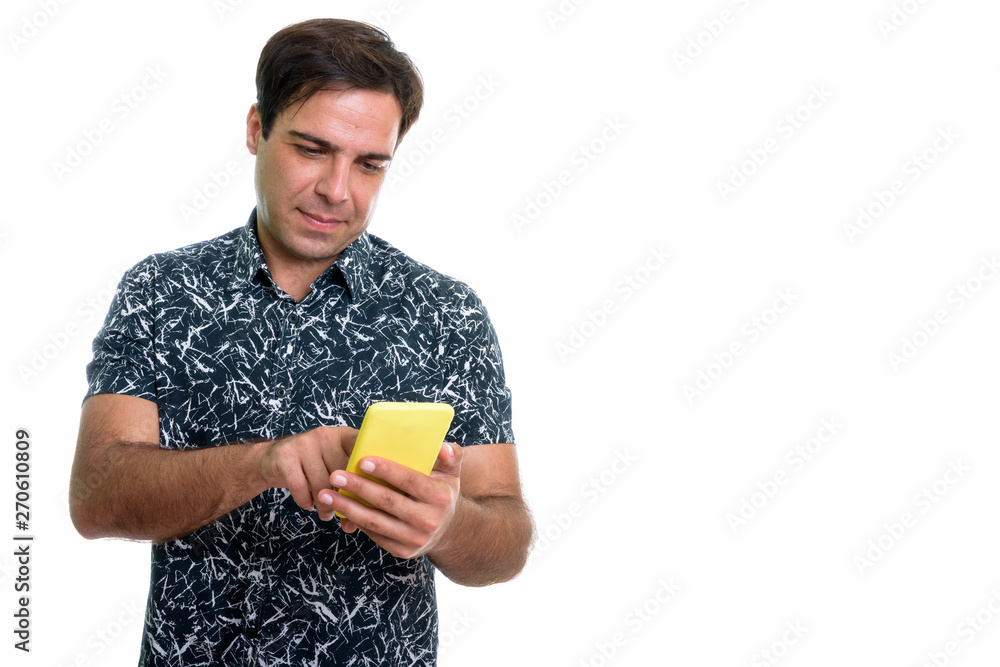 Young Persian man using mobile phone isolated against white back Young Persian man using mobile phone isolated against white back