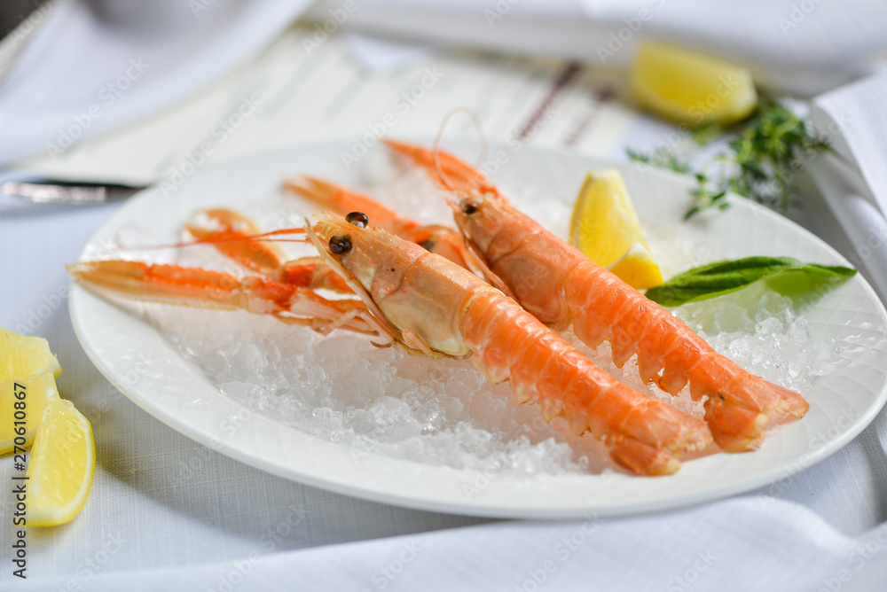 scampi on a plate with ice and lemon scampi on a plate with ice and lemon