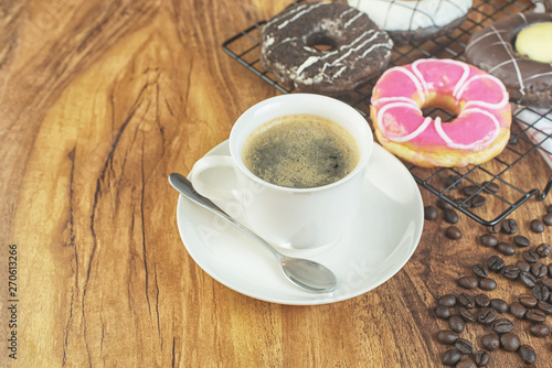 Coffee and donuts on wooden table. photo