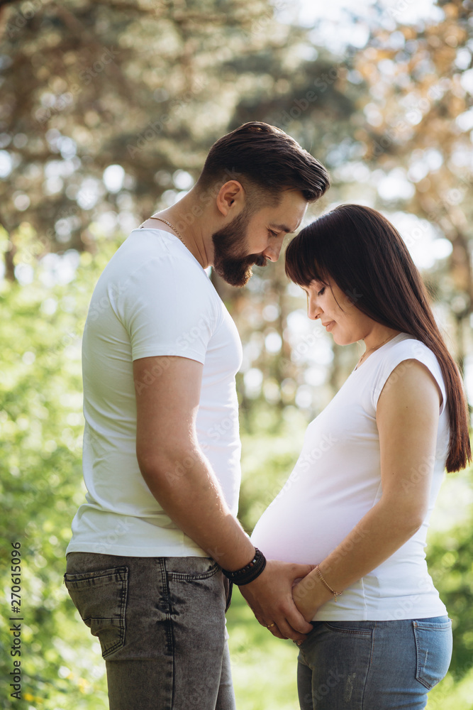 Happy young couple expecting baby in summer park Happy young couple expecting baby in summer park
