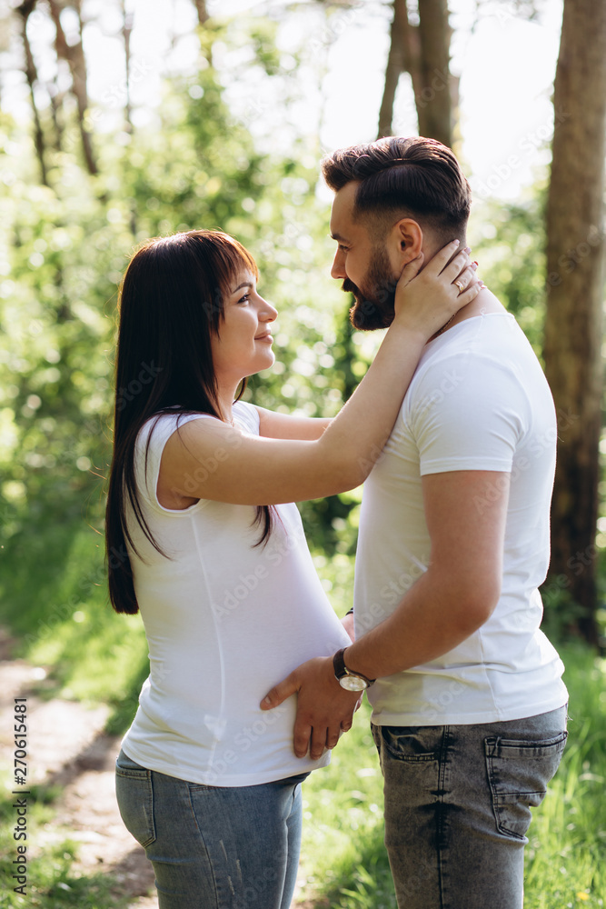 Happy young couple expecting baby in summer park Happy young couple expecting baby in summer park