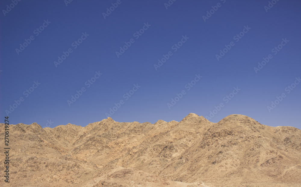 desert rocky mountain ridge background silhouette nature wallpaper pattern scenic landscape on blue sky background with empty space for copy or text