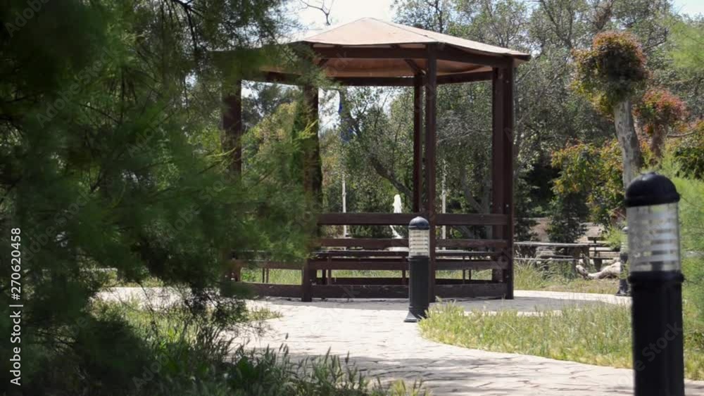 Enjoying day in the nature - scene from the park and gazebo with fountain water surounded by trees Enjoying day in the nature - scene from the park and gazebo with fountain water surounded by trees