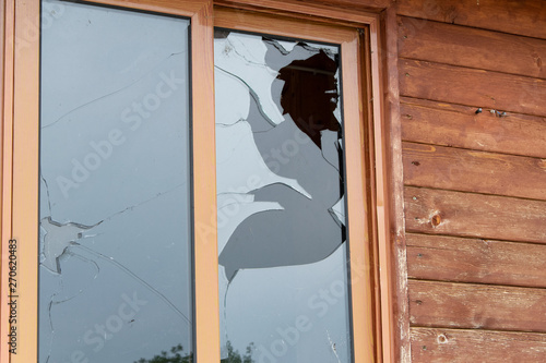 Close up view of cracked and broken glass window. Vandalism fracture
