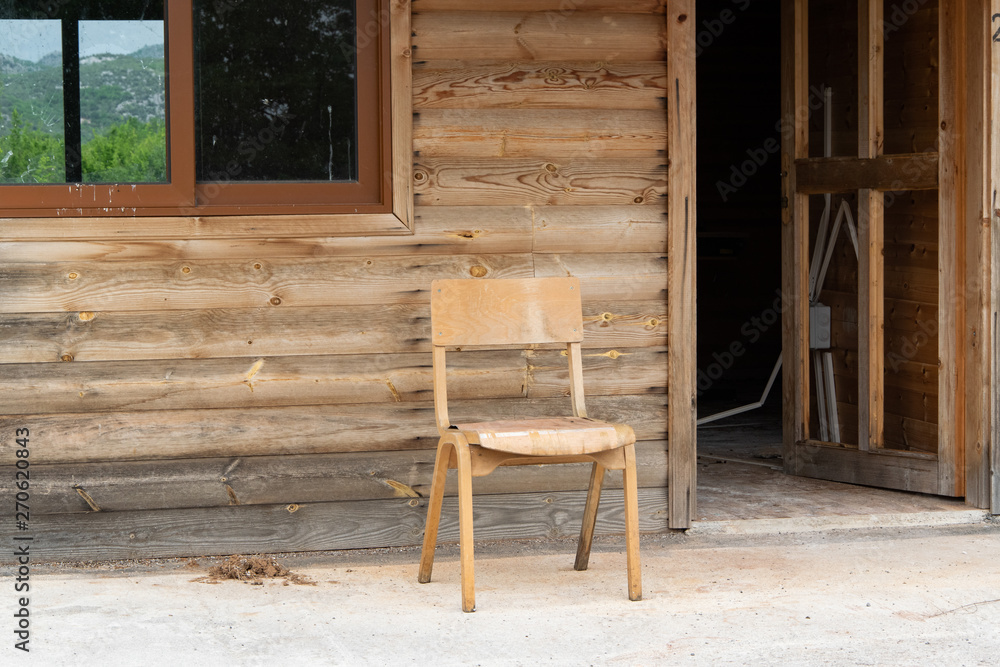 Old abandoned wooden house with chair outside