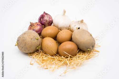 mix of egg potato onion and garlic on the nest with white background.