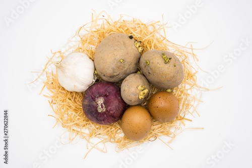 mix of egg potato onion and garlic on the nest with white background.