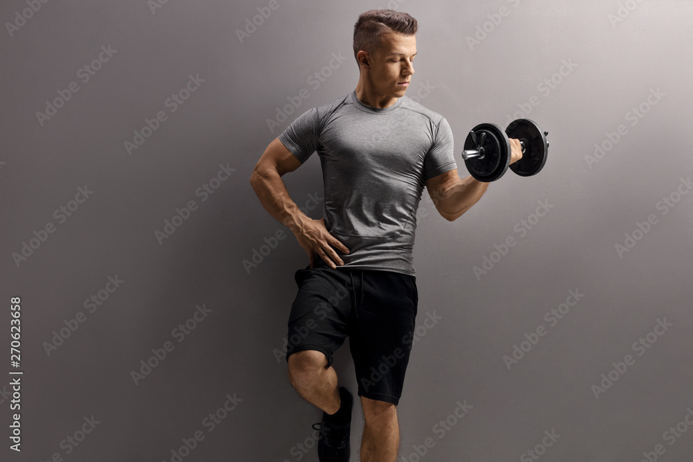 Fototapeta premium Young muscular man lifting a dumbbell