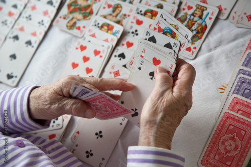 Canvas Print Closeup of wrinkled hands of senior lady playing solitaire