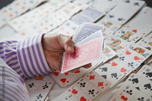 Canvas Print Closeup of wrinkled hands of senior lady playing solitaire
