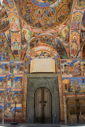 The front door of the church in the Rila monastery, Bulgaria. Religious frescoes on the Bible treatises, painted on the wall