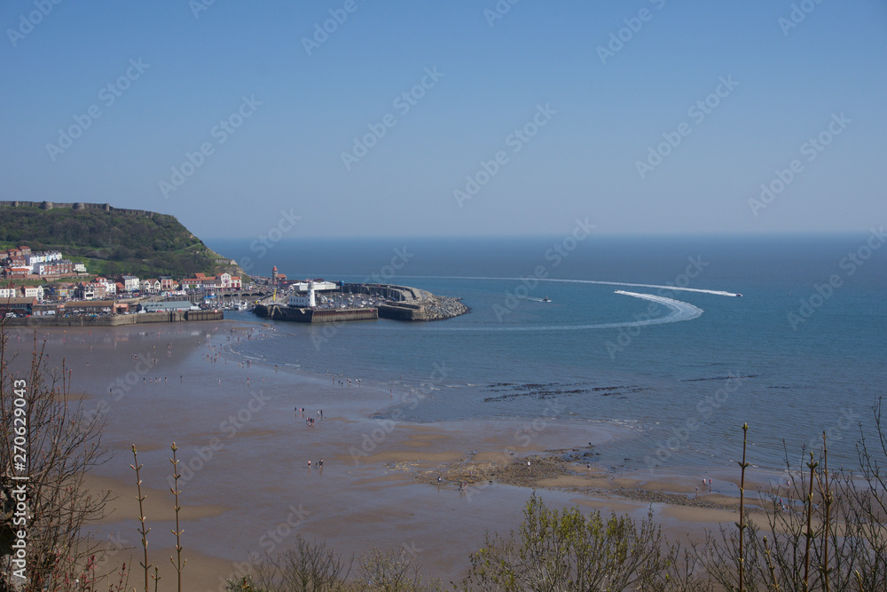 View from clifftops down to harbour in Scarborough, UK on a clear blue sky sunny day