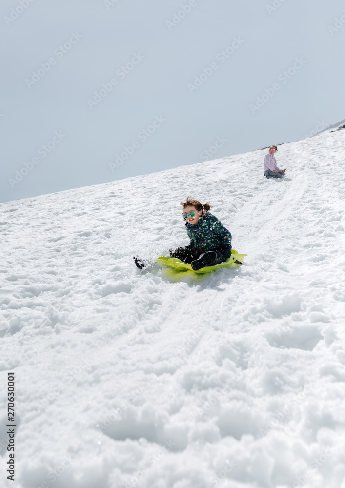 Mother with her daughter playing with a sled Mother with her daughter playing with a sled