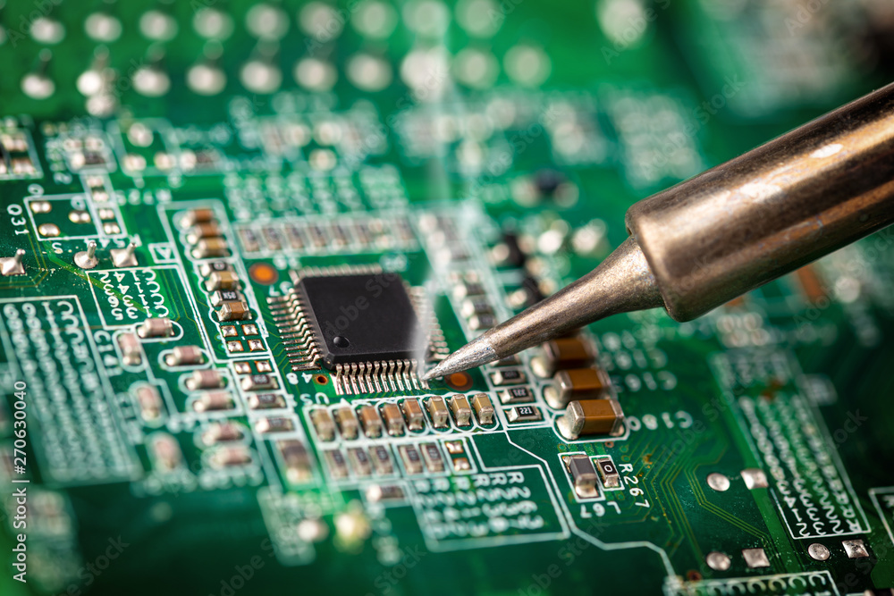 Soldering a micro chip processor with iron tool green circuit boad. Electroncs service technology and macro computer concept background. Soldering a micro chip processor with iron tool green circuit boad. Electroncs service technology and macro computer concept background.